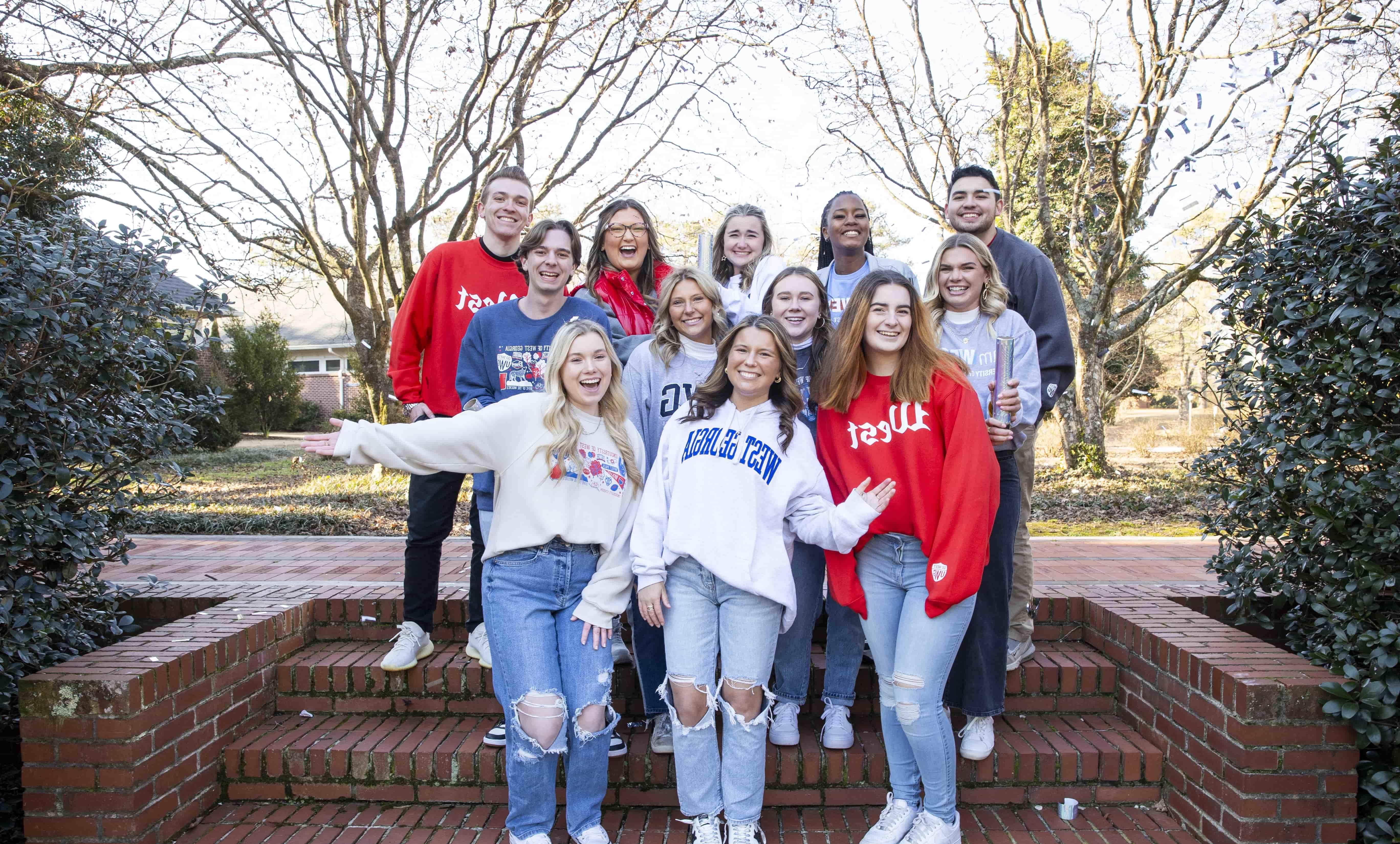 Spring 2024 Social Media Ambassadors pose for a group photo outside the Alumni House.